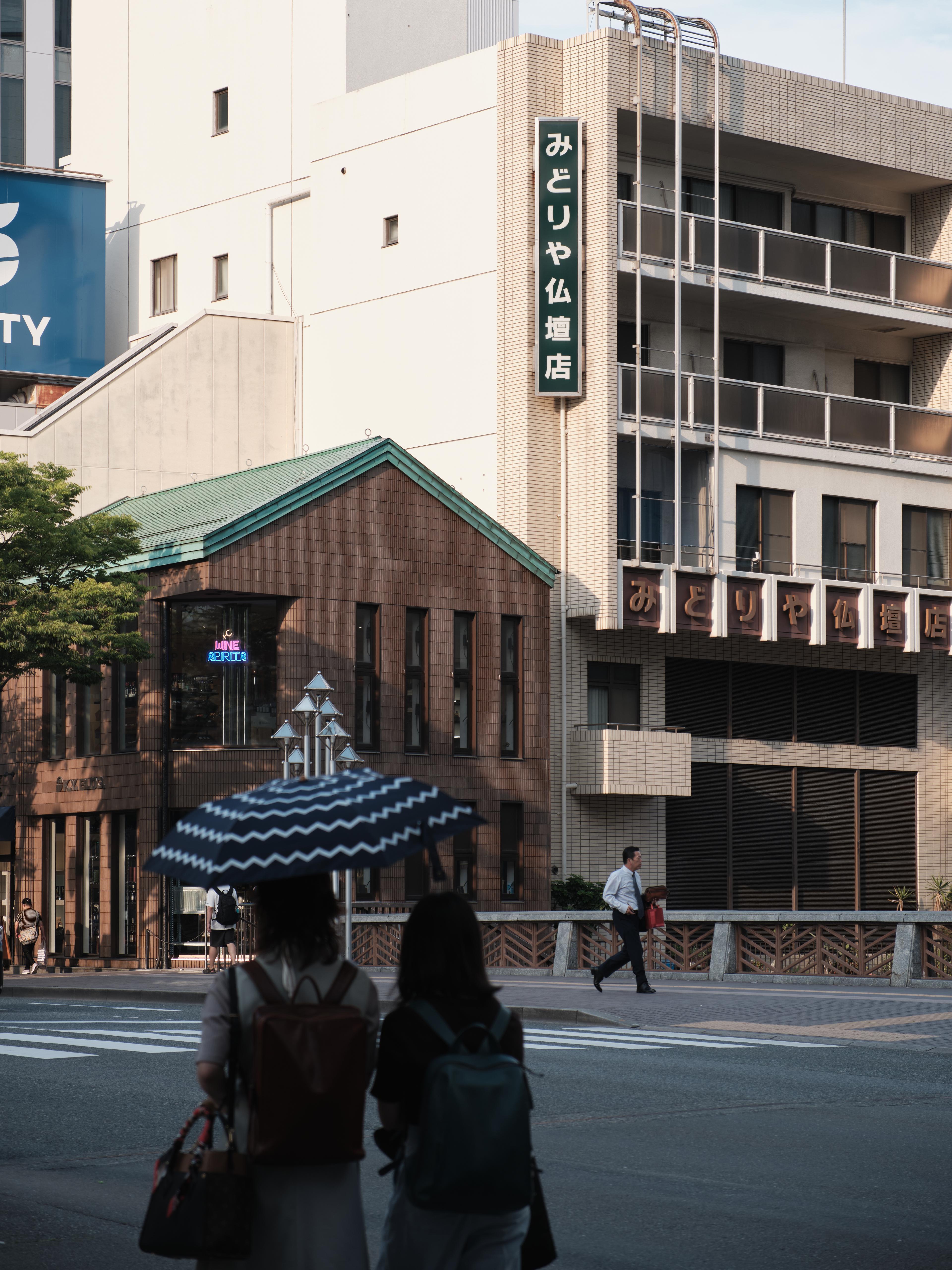 two girls waiting for red light while salaryman across the street running