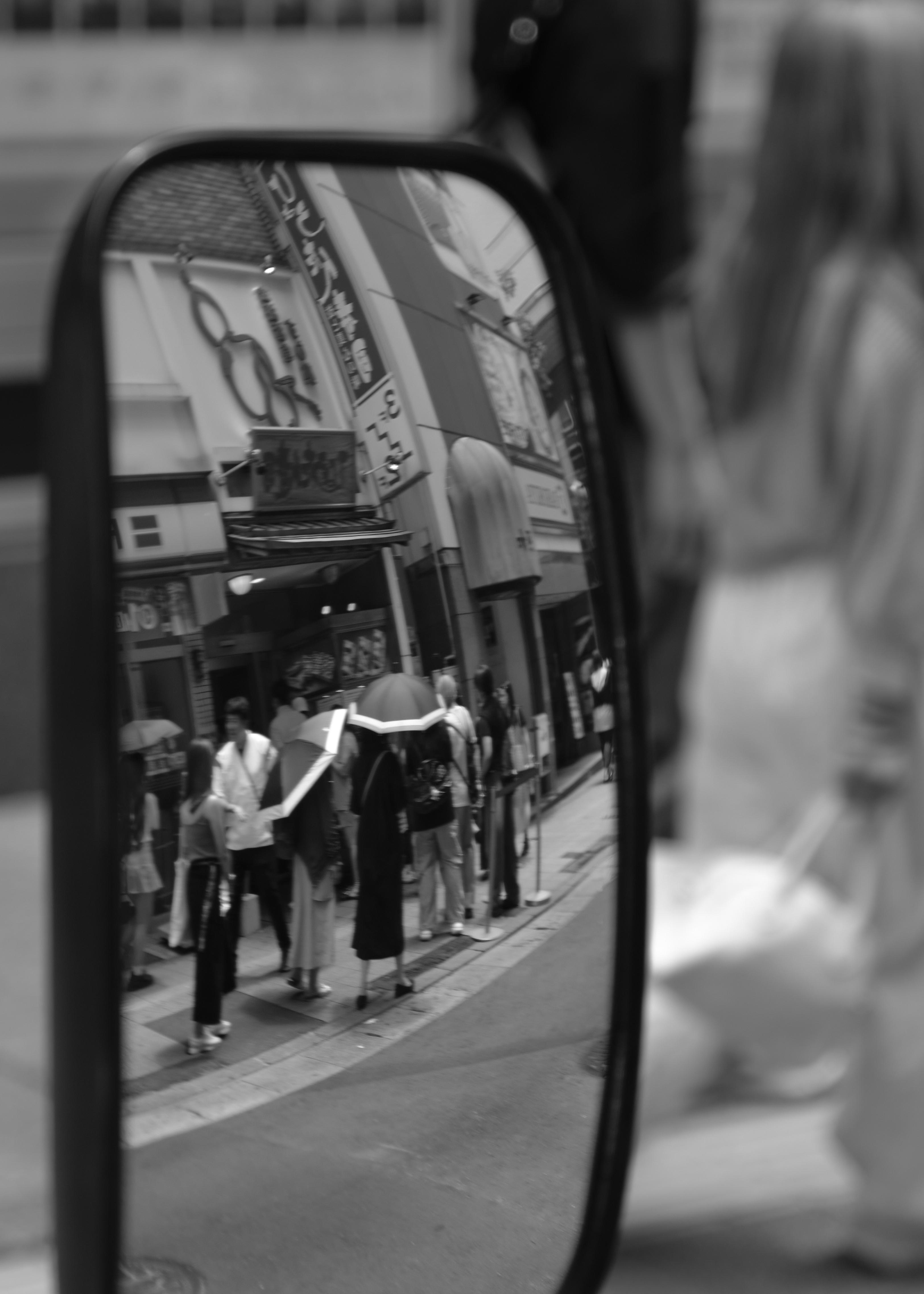 people queueing at sushi restaurant seen from mirror reflection